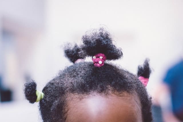 A black girl child wearing a pony tail.