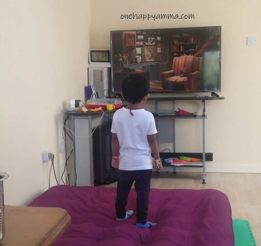 Toddler standing and watching TV on the air bed. One Happy Amma photo