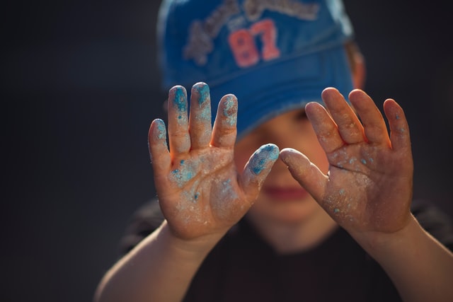 Toddler with sand and paint in his hands . Photo from unsplash used for 7 Creative Fun Activities for Toddlers at Home on One Happy Amma